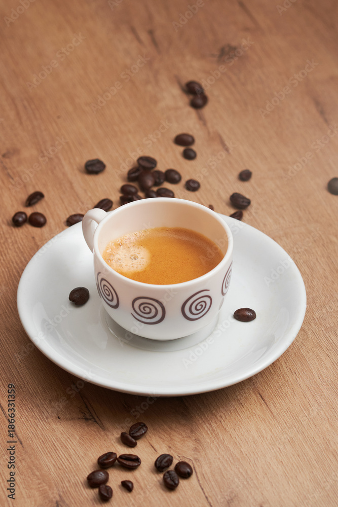 Obraz premium Minimal espresso cup on wooden table with coffee beans
