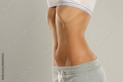 Bilde på lerret Side view of a woman’s torso with toned abdomen and slim waist, studio shot on a