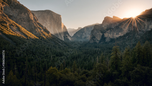 View of Yosemite Valley from Tunnel View point at the moment of sun rising above Cathedral Rocks with massive of El Capitan and half Dome lit by sun, Yosemite National Park, California, USA