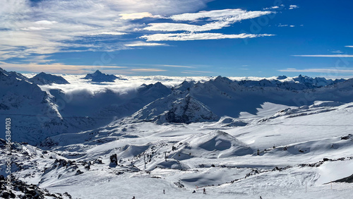 Majestic alpine panorama unfolds beneath a cerulean sky, evoking winter solstice reveries and the serene art of zen sliding