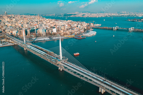 The Golden Horn Metro Bridge and Galata Bridge rise above the blue waters as ships move through the channel in a broad Istanbul landscape.