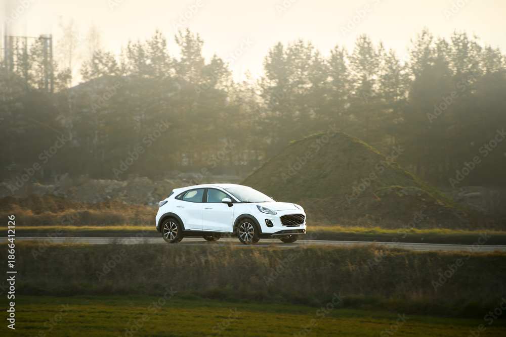 Fototapeta premium Crossover vehicle driving in sunlight