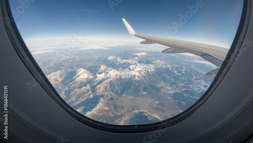 Airplane window frame from the beautiful snowy mountais of Austrian Tyrol