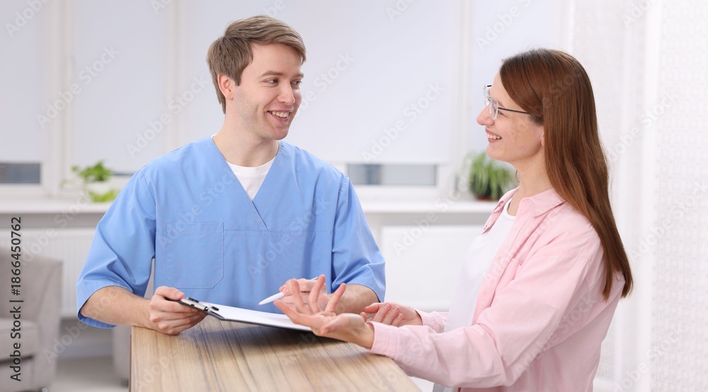 Obraz premium Medical assistant helping patient at reception in clinic