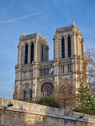 View from a cruising boat along the Seine River to the magnificent Notre-Dame Cathedral facade in Paris, France