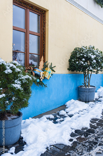 balcony with flowers and small tree in snowed covered and gifts christmas 