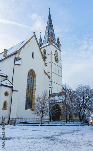 big old chruch cathedral evangelic german style with huge tower in winter garden and snow