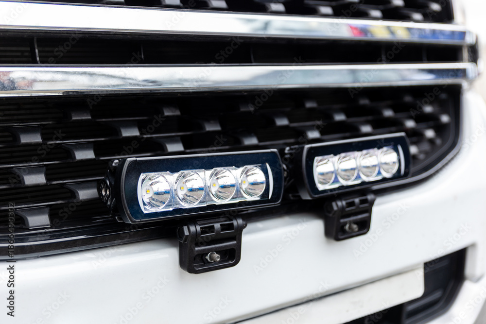 Fototapeta premium Closeup of vehicle grille with integrated LED strobe lights mounted on bumper, showing modern emergency lighting system for unmarked patrol or service car. Automotive safety equipment visible