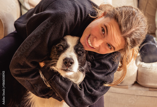 Woman hugging old border collie dog demonstrating love