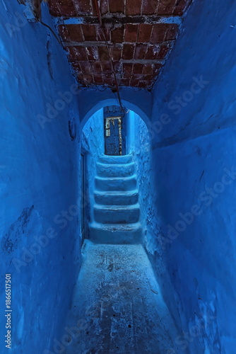 Narrow passageway in the medina under a brick and beam framework supporting houses, painted as is customary in shades of blue. Chefchaouen-Morocco-023