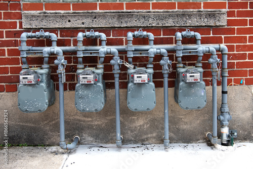Residential building utility system with gas meters and metal pipes