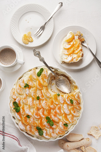 Tangerine tiramisu orange tiramisu on the plate and dish on white table, top view