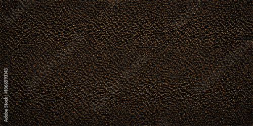 A macro closeup of natural black and brown leather texture material with a dark rough surface pattern for a textured fabric background design