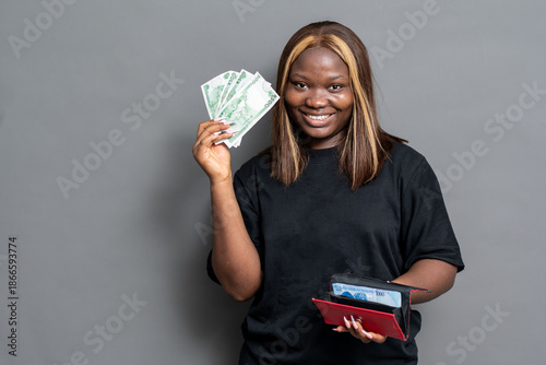 Bild auf Leinwand Happy NIgerian woman flaunting some cash from her purse