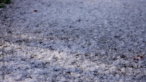 Snowflakes falling on dark asphalt road in close up, 4K
