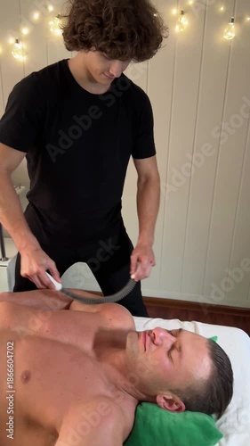 A therapist applies massage cups to the chest of a male client as part of a therapeutic cupping treatment
