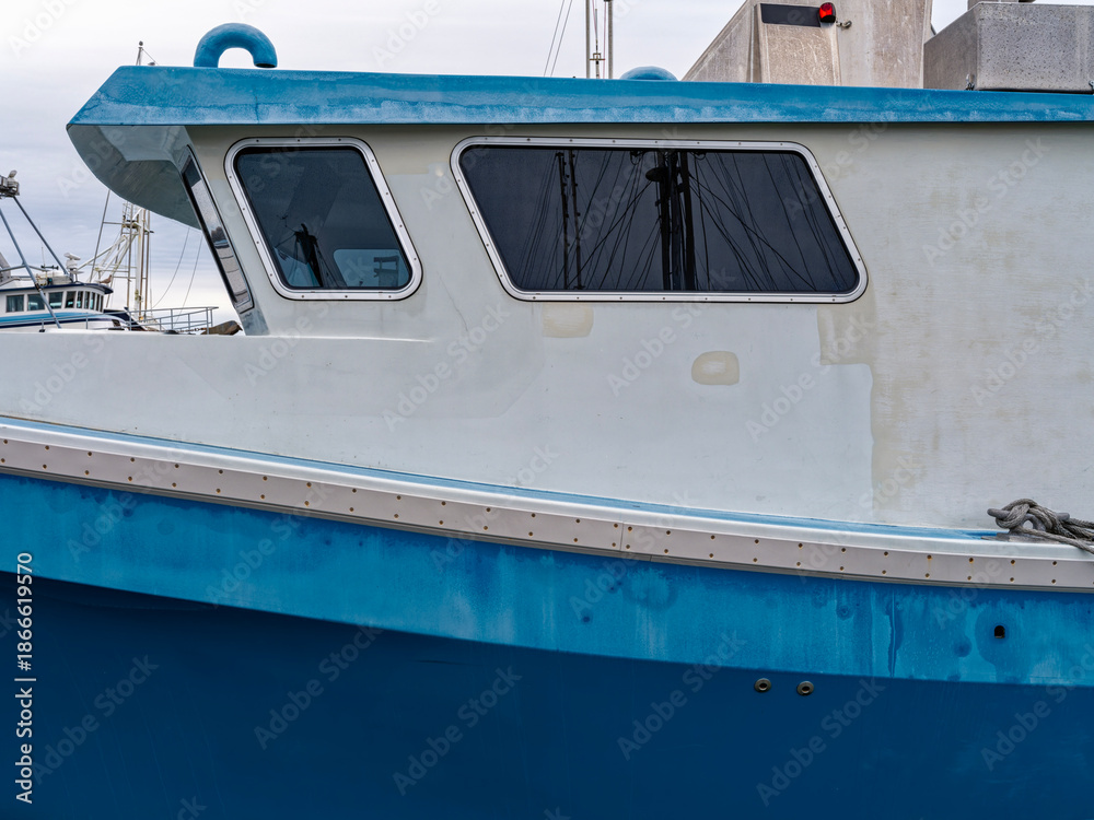 Naklejka premium The cabin or wheelhouse of a commercial fishing vessel docked at a marina on the Pacific coast