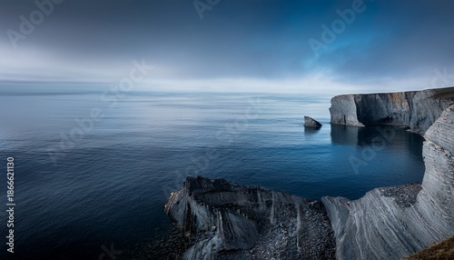 coastal cliff erosion with calm waters a muted palette of grays and blues