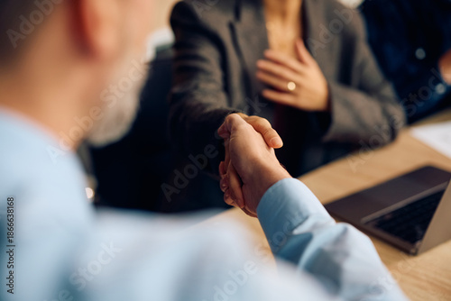 Foto Close up of business people shaking hands on meeting in office.