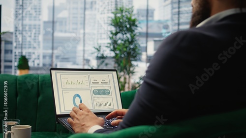 Confident leader reviews sales trends and budget reports in his smart office, ensuring profitability and company success through effective decision making and strategic planning. Camera A.