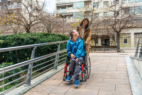Canvastavla Caretaker pushing young man in wheelchair outdoors