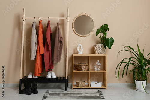 Rack with autumn clothes an...