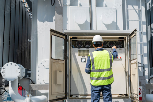 Bild auf Leinwand Engineer inspecting transformer control panel at power substation, monitoring electrical equipment and ensuring safe and reliable operation of high voltage energy infrastructure