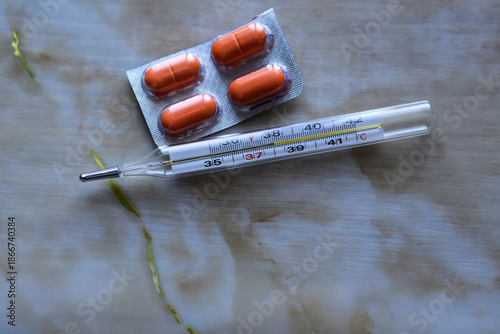 thermometer and pills on the table