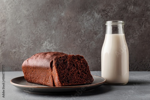 Freshly baked loaf of bread sits next to a glass bottle filled with milk