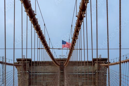 View of Brooklyn Bridge American flag flying with cables towers visible