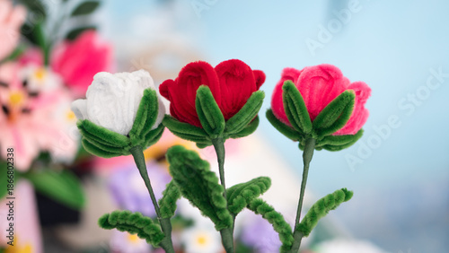 Handmade artificial rose flowers made from colorful fuzzy pipe cleaners or chenille stems. Red, pink and white DIY craft gift for Valentine's Day or Mother's Day love concept.