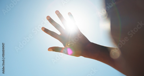 Φωτογραφία Person, outdoor and hand in sunshine with glare, eye protection and blue sky on holiday