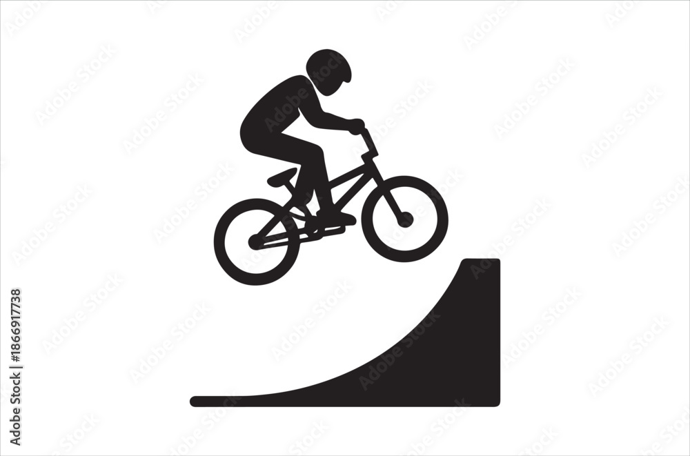 Fototapeta premium A silhouette of a cyclist performing a jump on a ramp