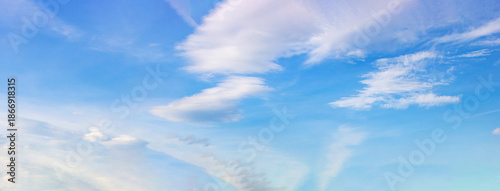 Layered cloud formations in textured blue sky—ideal as a natural atmospheric background with depth, softness, and visual scale for design, presentation, or compositional use.
