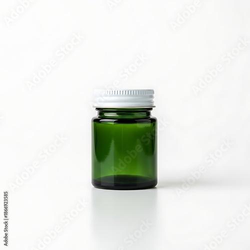 Small green glass medicine bottle with white screw cap isolated on a white background