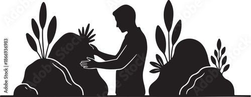 Silhouette of a person planting a seedling in rocky terrain