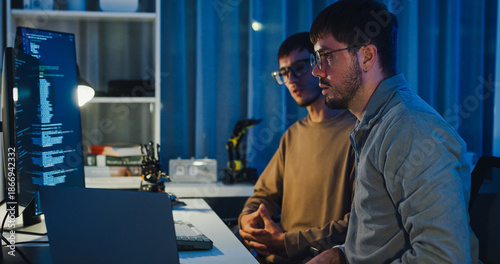 Foto Team adult male engineer collaborate on robotic hand project using AI code solutions machine learning at tech workspace night
