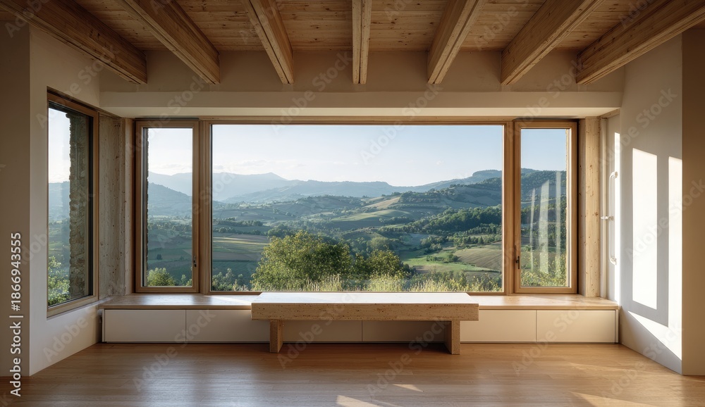 Fototapeta premium A bright, sunlit interior with a large window framing a scenic mountain vista