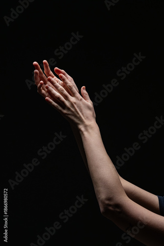 Wallpaper Mural Close-up of two female hands with red nails in an expressive, illuminated pose against a dark backdrop. A minimal, artistic composition Torontodigital.ca