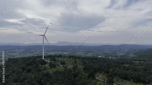 Closeup beautiful solo wind turbine at green mountain hill clean sustainable electricity power, Green generator cloud blue sky