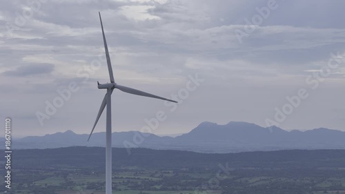 Closeup beautiful solo wind turbine at green mountain hill clean sustainable electricity power, Green generator cloud blue sky