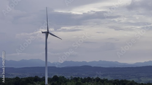Closeup beautiful solo wind turbine at green mountain hill clean sustainable electricity power, Green generator cloud blue sky
