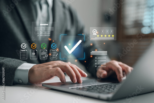 Fotografie Businessman using laptop to manage digital checklist and quality assurance system, verifying tasks and documents for approval with high rating and compliance interface