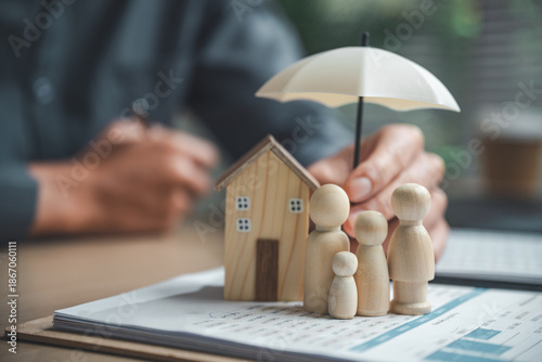 Bild auf Leinwand Home insurance and family protection concept showing a house and family figures under an umbrella, symbolizing property coverage, risk management, homeowner safety, and long-term financial security