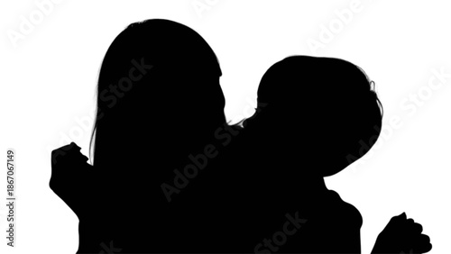 A loving mother embracing her young child in a tender moment captured as a striking silhouette