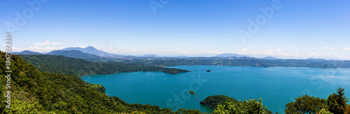 Принти на полотні Panoramic Landscape of Lake Surrounded by Lush Green Forest and Mountains