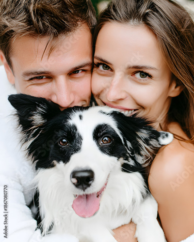 Joyful couple embracing their happy dog in a lush outdoor setting