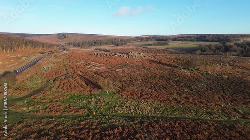 Aerial drone footage pushing forward toward Owler Tor in Derbyshire, England, showing rock formations and moorland, suitable for travel, landscape, environment and establishing shot use.