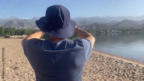 man making picture panorama lake beach mountains amateur mobile phone