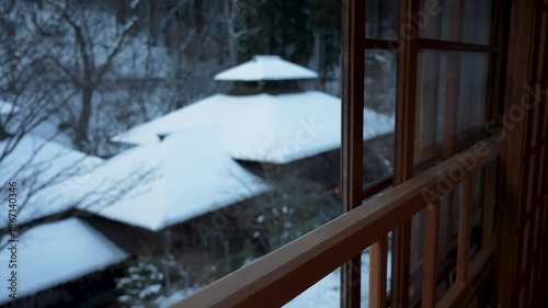 Serene winter landscape viewed through a traditional Japanese Ryokan window